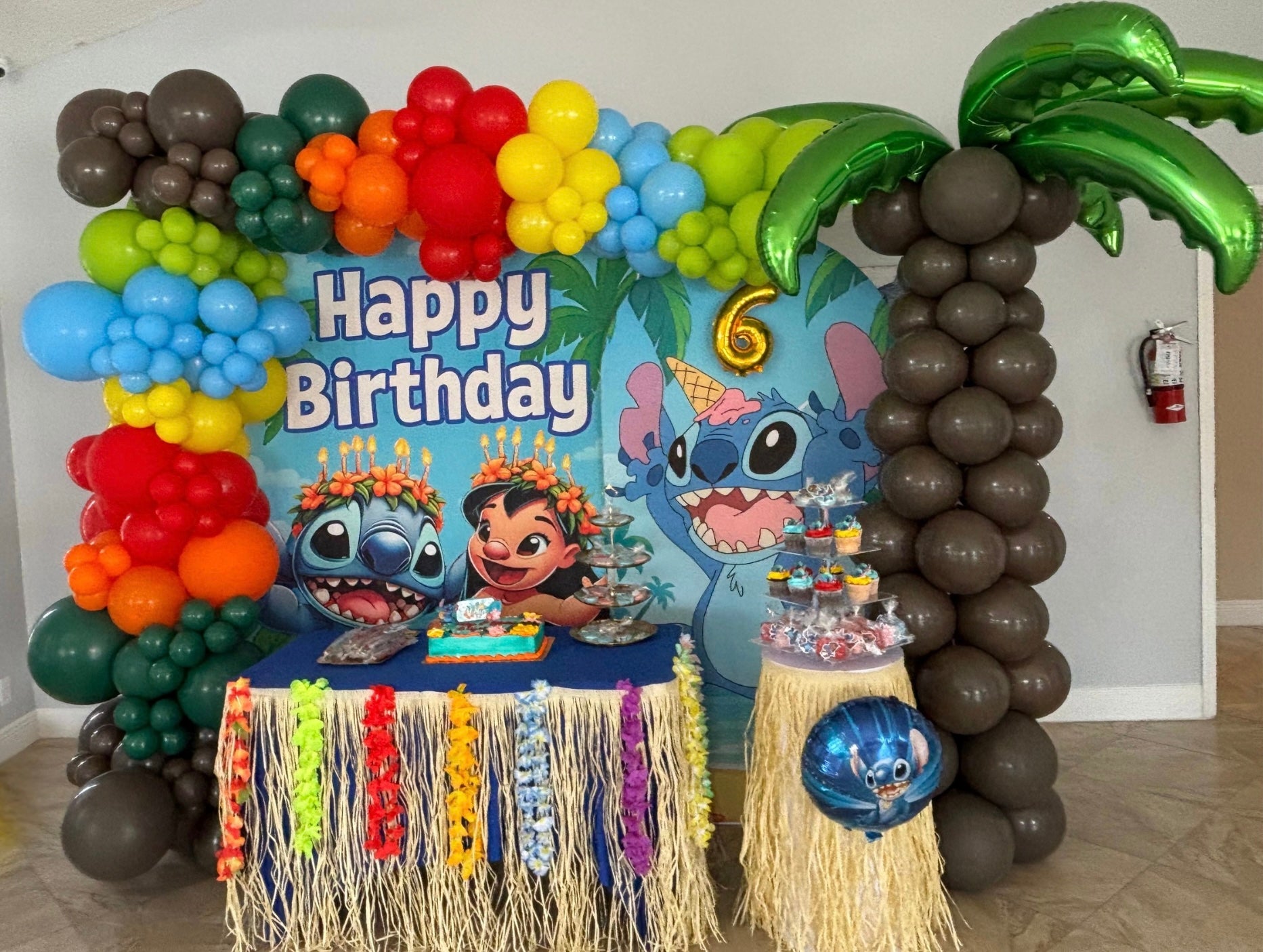 Tropical Blue alien Character Birthday Set Up with bright balloons and a balloon coconut tree 